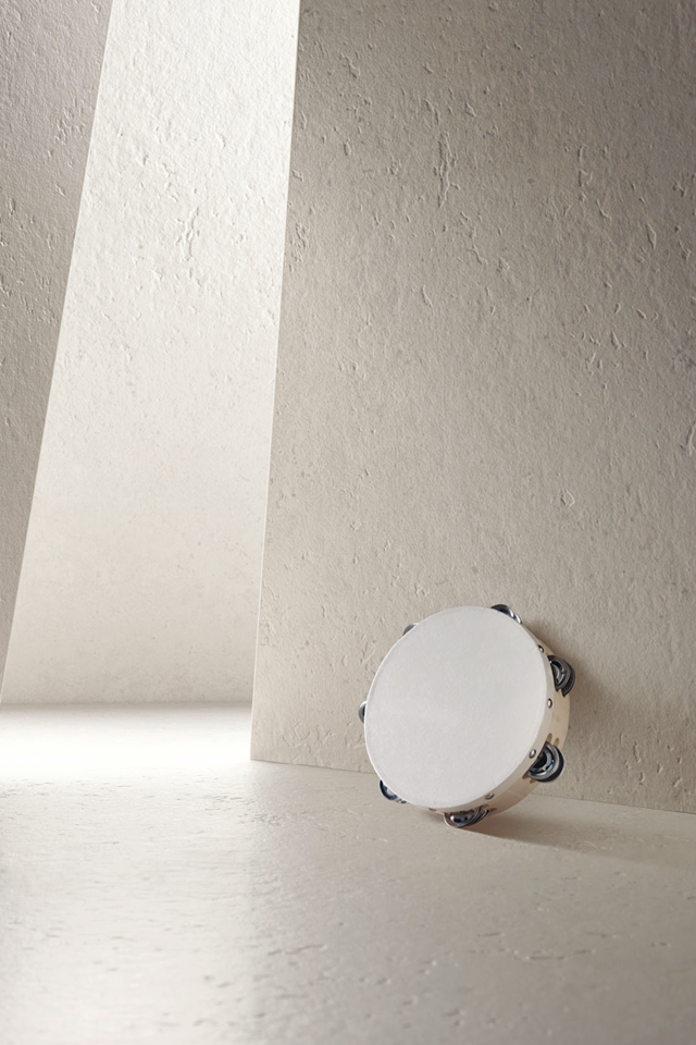 Die Struktur Taranta FD28 ist in einem Raum inszeniert. Die beige Natursteinoptik ist auf senkrechten Flächen zu sehen, die sich nach Hinten zu einem Gang öffnen.